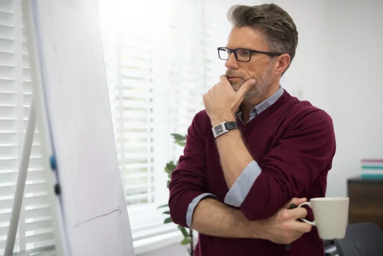 a man in glasses looking at a white board-Men's Health Coaching & Fitness Training